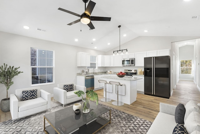 living room featuring ceiling fan, visible vents, lofted ceiling, recessed lighting, and light wood-style flooring