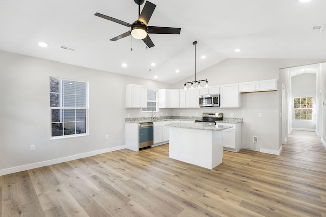 kitchen with visible vents, a center island, white cabinets, a ceiling fan, and appliances with stainless steel finishes