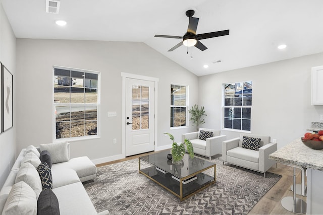 living room featuring vaulted ceiling, a ceiling fan, wood finished floors, and visible vents