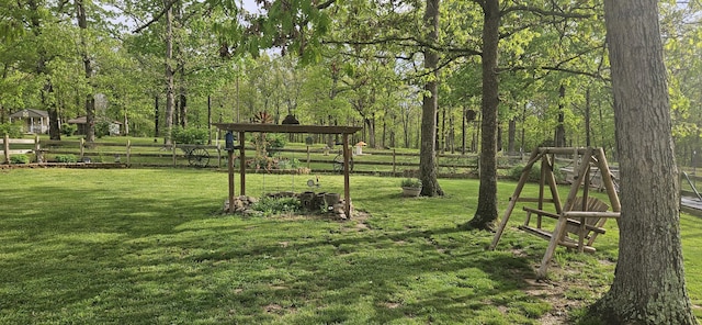 view of community with fence and a yard