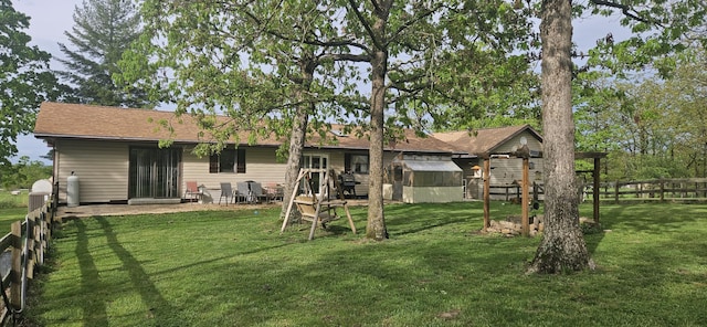 back of house with an outdoor structure, fence, and a yard