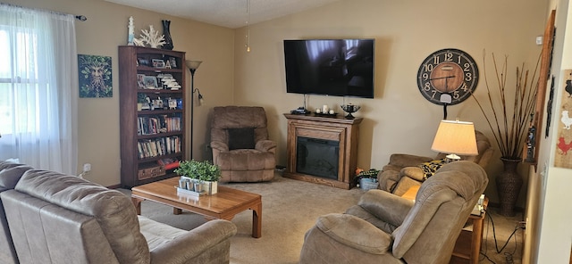carpeted living room featuring a glass covered fireplace and lofted ceiling