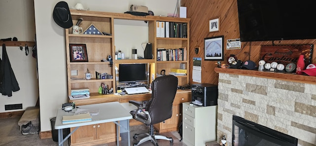 office space with wooden walls and a glass covered fireplace