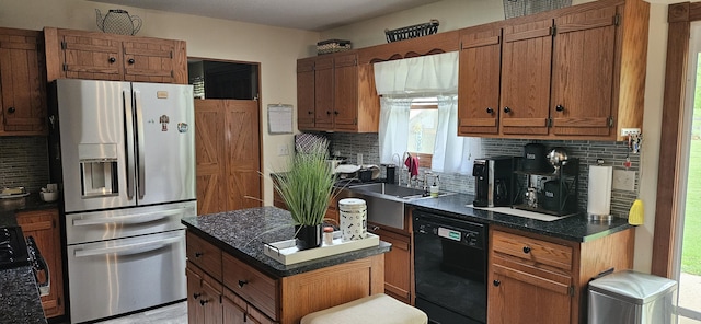 kitchen with brown cabinets, dark countertops, stainless steel fridge, black dishwasher, and decorative backsplash