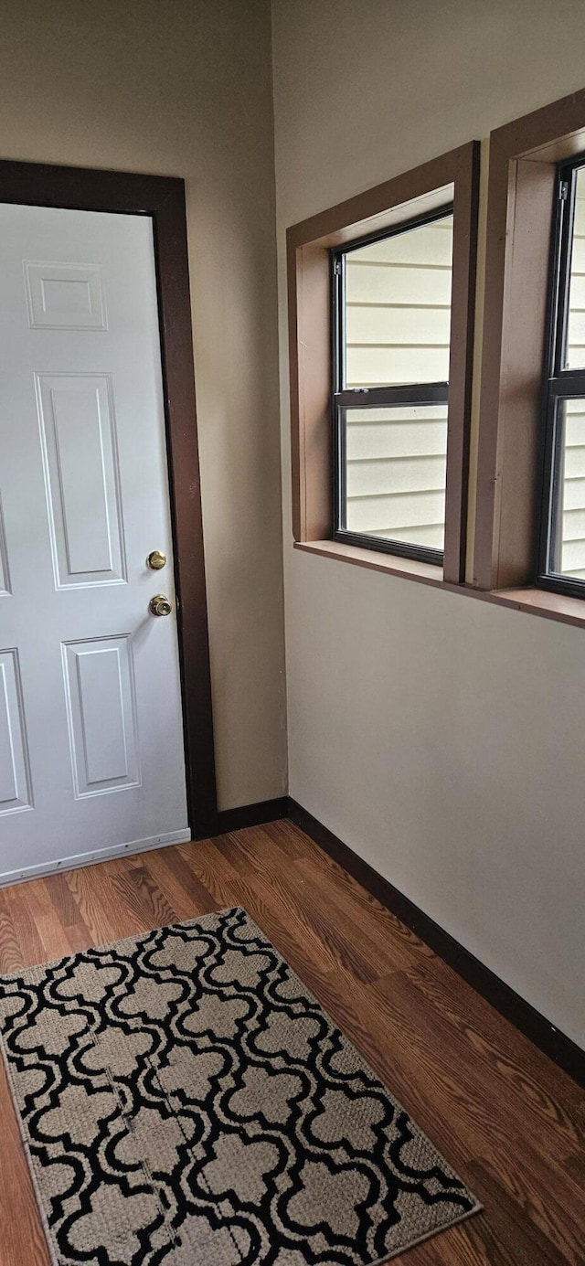 interior space with baseboards and wood finished floors