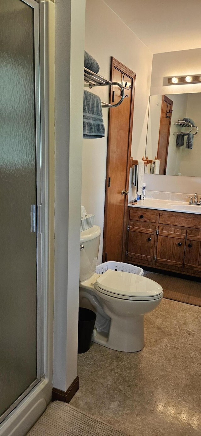 bathroom with vanity, a shower stall, and toilet