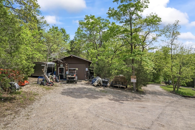 rear view of house with an outdoor structure, driveway, and a detached garage