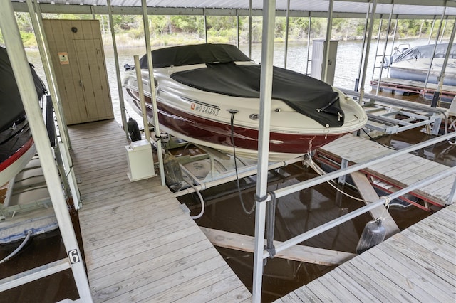 view of dock with boat lift and a water view