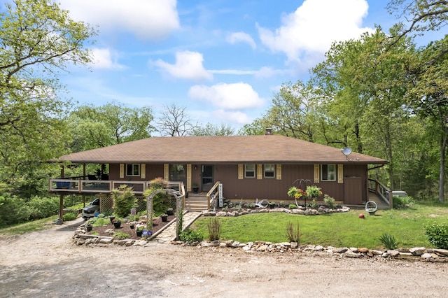 view of front of property with dirt driveway, a carport, a porch, and a front lawn