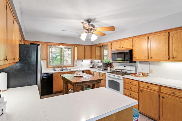 kitchen with a peninsula, ceiling fan, light countertops, a sink, and appliances with stainless steel finishes