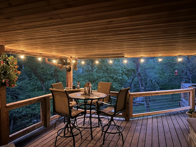 deck at twilight with outdoor dining space