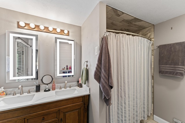 bathroom with a sink, a textured ceiling, double vanity, and a shower with shower curtain