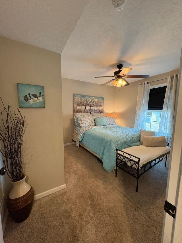 bedroom with carpet flooring, a textured ceiling, baseboards, and ceiling fan