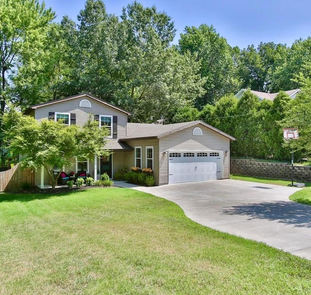 tri-level home featuring a garage, a front lawn, fence, and concrete driveway