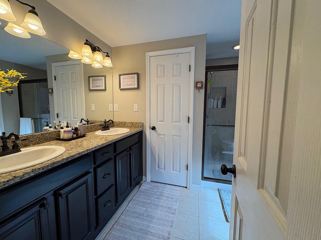 bathroom with a sink, tile patterned floors, a shower stall, and double vanity