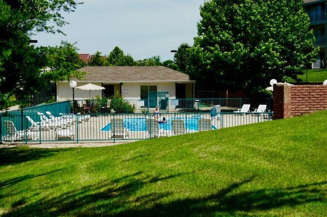 pool featuring a lawn and fence
