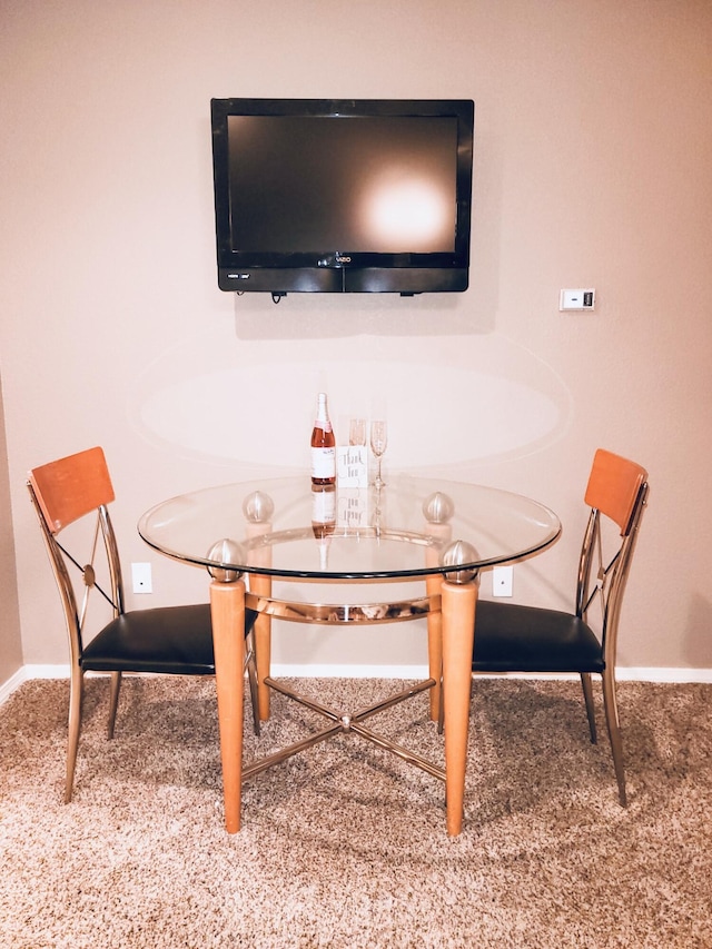 carpeted dining area with baseboards