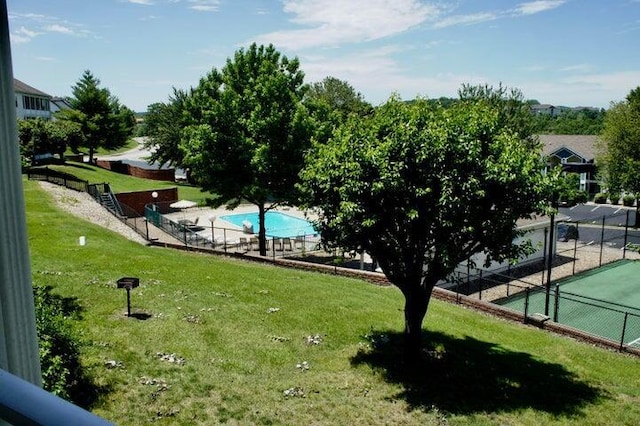 surrounding community featuring fence and a yard