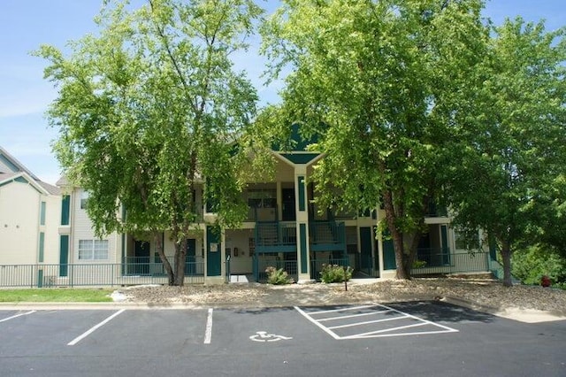 view of property with fence and uncovered parking