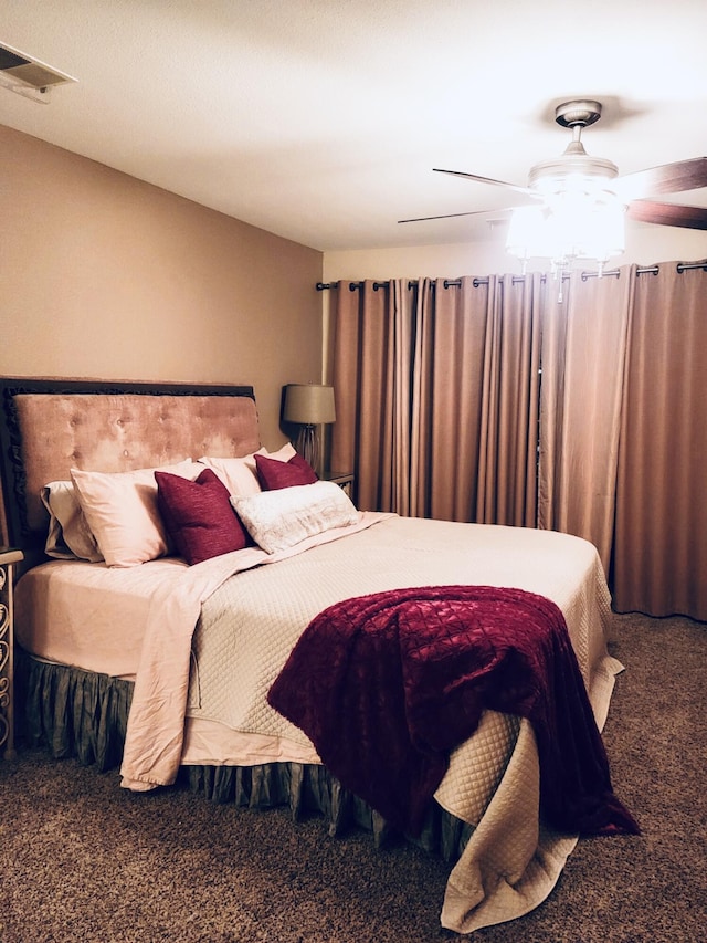 carpeted bedroom with a ceiling fan and visible vents