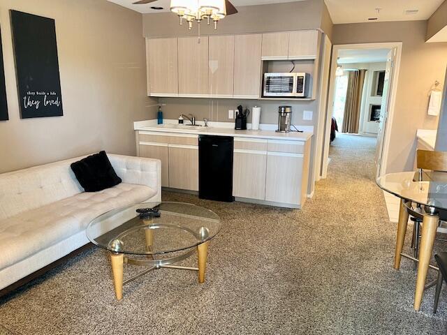 530 Spring Creek Ct Unit 7, Branson, MO 65616 - kitchen with stainless steel microwave, dishwasher, light carpet, and light countertops