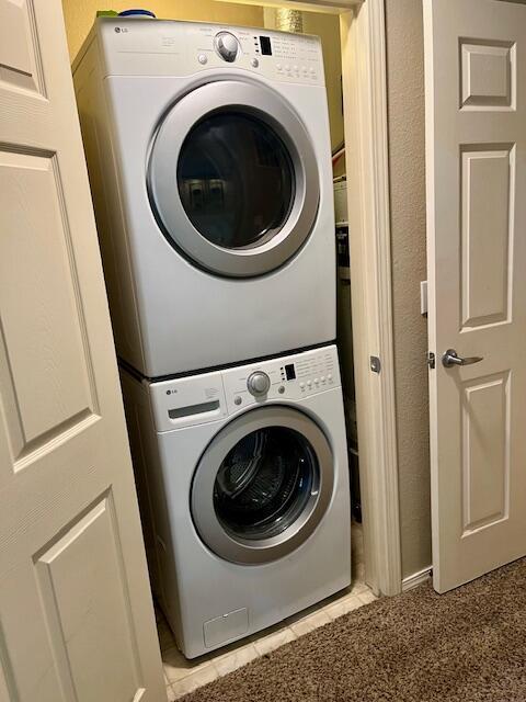 530 Spring Creek Ct Unit 7, Branson, MO 65616 - washroom with stacked washer / dryer and light tile patterned floors