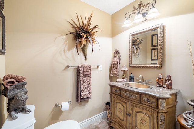 bathroom with toilet, baseboards, and vanity