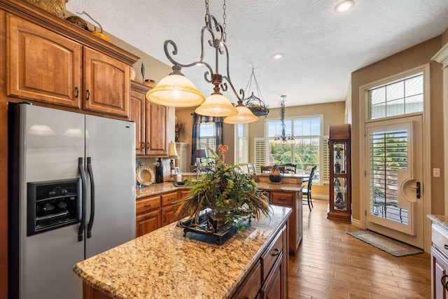 kitchen featuring a chandelier, brown cabinetry, stainless steel fridge with ice dispenser, and hardwood / wood-style floors