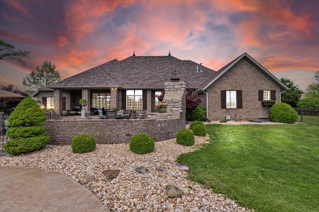 ranch-style home featuring fence, a patio area, a front lawn, and brick siding