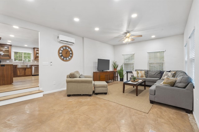 living room featuring finished concrete flooring, a wall unit AC, a ceiling fan, and recessed lighting