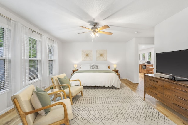 bedroom with baseboards, ceiling fan, and light wood finished floors