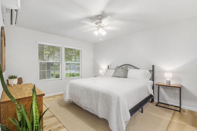 bedroom with baseboards, ceiling fan, and light wood-style floors