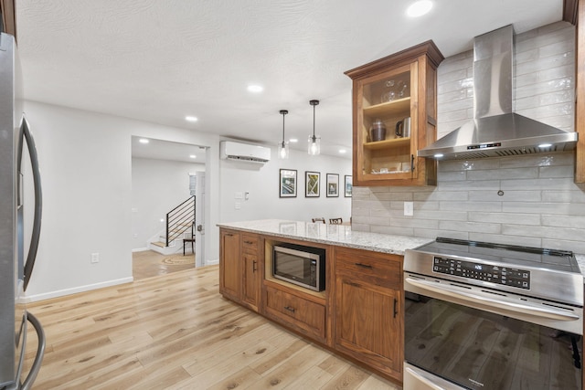 kitchen with appliances with stainless steel finishes, tasteful backsplash, brown cabinetry, and wall chimney exhaust hood