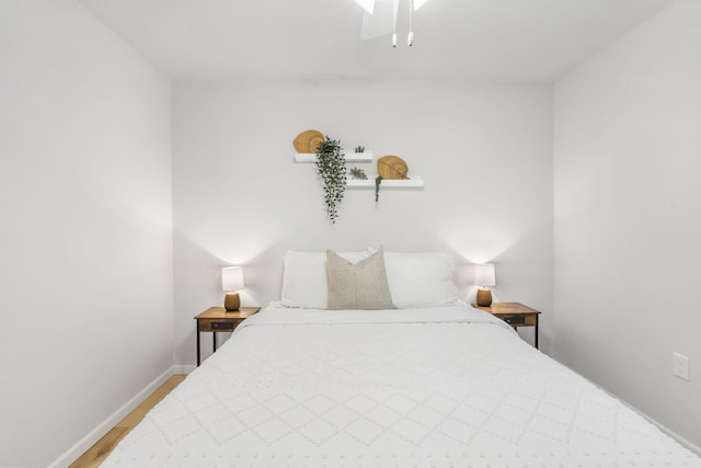 bedroom with baseboards and wood finished floors