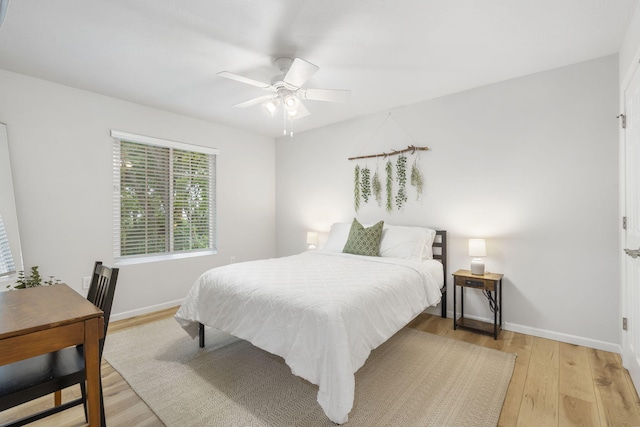 bedroom featuring light wood-type flooring, a ceiling fan, and baseboards