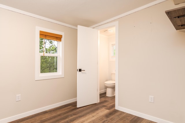 unfurnished bedroom featuring baseboards, ornamental molding, and dark wood finished floors
