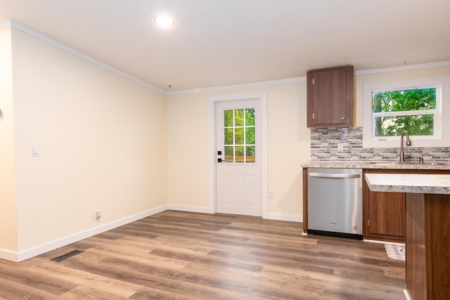 kitchen with a sink, light wood finished floors, light countertops, stainless steel dishwasher, and visible vents