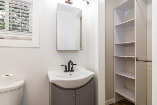 half bathroom with vanity and toilet