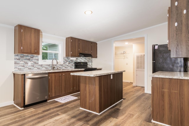 kitchen with crown molding, a sink, under cabinet range hood, and black appliances