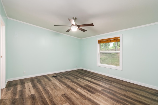 spare room with dark wood-style flooring, baseboards, ornamental molding, and a ceiling fan
