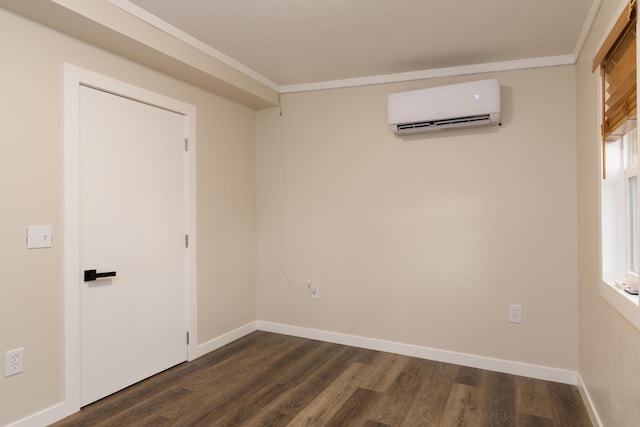 empty room featuring an AC wall unit, crown molding, baseboards, and dark wood-type flooring