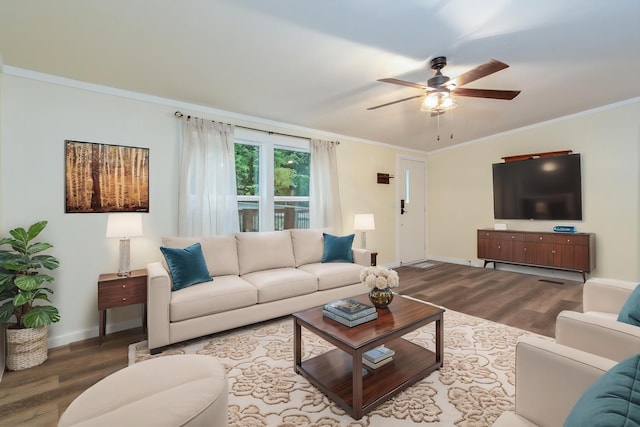 living room featuring crown molding, ceiling fan, baseboards, and wood finished floors