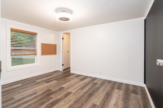 unfurnished room featuring crown molding, baseboards, and wood finished floors