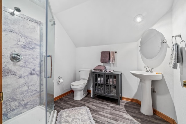bathroom with wood finished floors, baseboards, a stall shower, and toilet