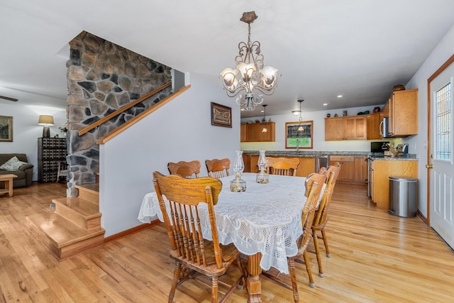 dining space featuring light wood-style floors and an inviting chandelier