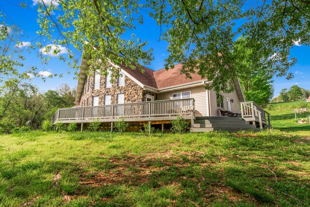 rear view of house with a deck and stone siding