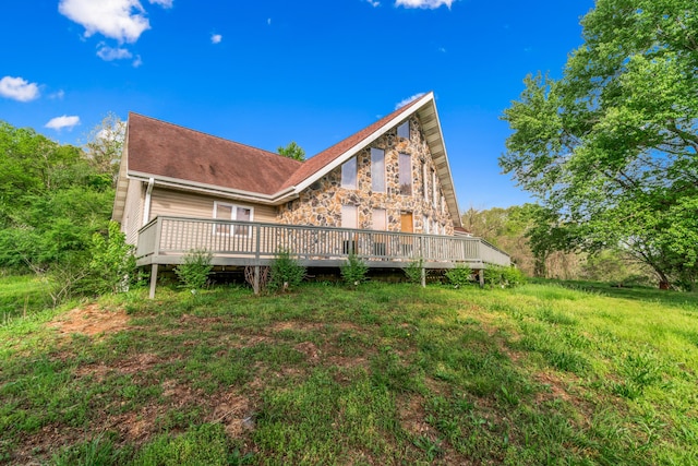 back of property featuring a deck and stone siding