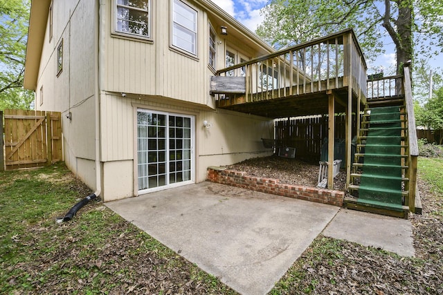 rear view of house with a wooden deck, fence, a gate, a patio area, and stairway
