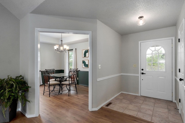 523 E Camino St, Springfield, MO 65810 - entryway with a textured ceiling, visible vents, baseboards, a notable chandelier, and light wood-style flooring
