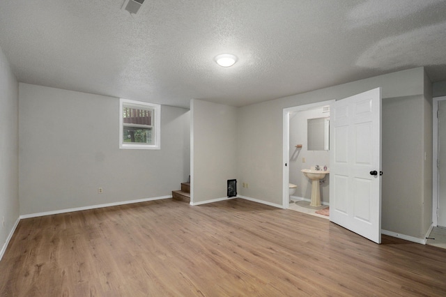 523 E Camino St, Springfield, MO 65810 - below grade area featuring baseboards, visible vents, a textured ceiling, and wood finished floors